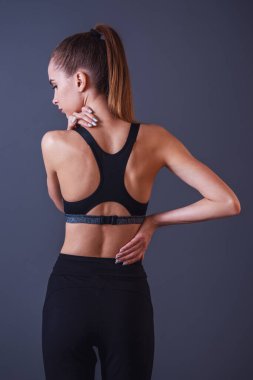 Spor giyim, güzel kızı arkadan görünüm gri arka plan üzerinde