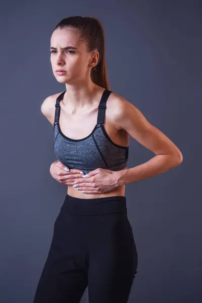 Beautiful Girl Sportswear Touching Her Stomach Feeling Pain Gray Background — Stock Photo, Image