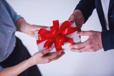 İki beyaz izole bir hediye kutusu tutarak Ofis kıyafetleri içinde kırpılmış görüntü