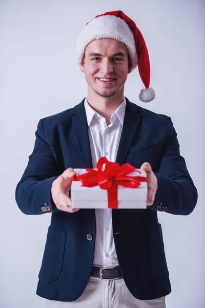 Knappe Man Pak Kerstmuts Houdt Een Doos Van Gift Camera Stockafbeelding