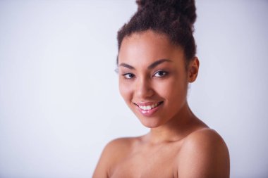 Güzel kız kameraya bakıyor ve gülümsüyor.