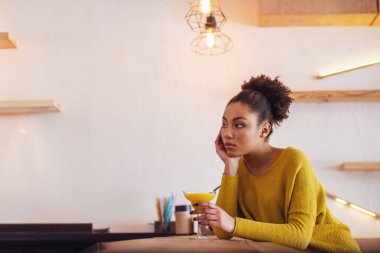 Afro Amerikan Kız güzel rahat kıyafetler kokteyl ve düşünme kafede istirahat ederken içiyor