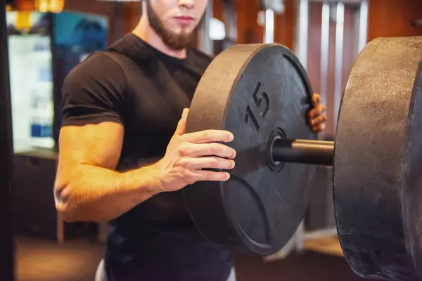 Young Strong Man Adds Weight His Barbell While Training Gym Royalty Free Stock Photos