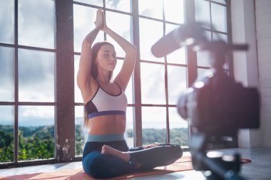 Büyük pencere arka planda evde fitness egzersiz çekim sırasında Genç güzel kız blogger