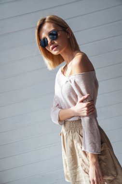 Güneş gözlüklü ve evde kameraya gülümseyen güzel bir kızın portresi.