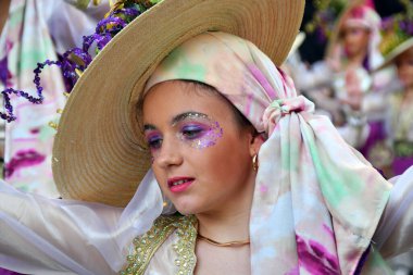 TORREVIEJA, SPAIN FEBRUARY 12, 2023: Participants dressed in a colorful carnival costumes on the street during the traditional Mardi Gras parade in Spain