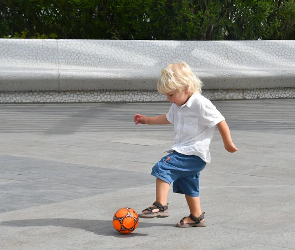 小男孩在空旷的广场上踢足球 夏天带着球活动的孩子 — 图库照片