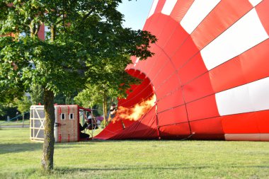 Şehir parkında havalanmadan önce sıcak hava balonu şişiyor.