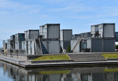 Complex of modular wicker cabins for holidays. Houses made of sea Containers for rent on Curonian bay in Svencele, Lithuania clipart