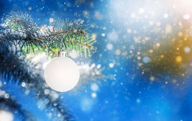 Noel ağacı süslemelerle süslenmiş, kışlık ve soyut bir manzaraya karşı..