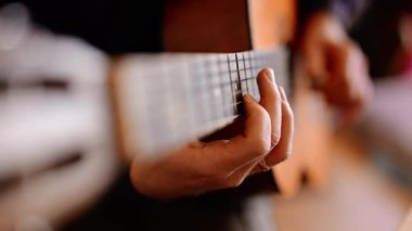 Gitar çalan, duygusal melodiler yaratan bir adamın parmakları.
