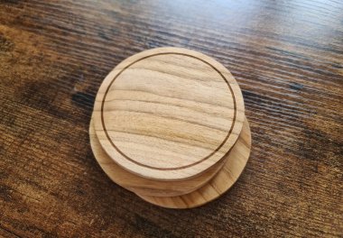 Ahşap yüzeyinde ahşap dokusu olan boş kahverengi bardak altlığı. Dairesel içecek yığını şablonu