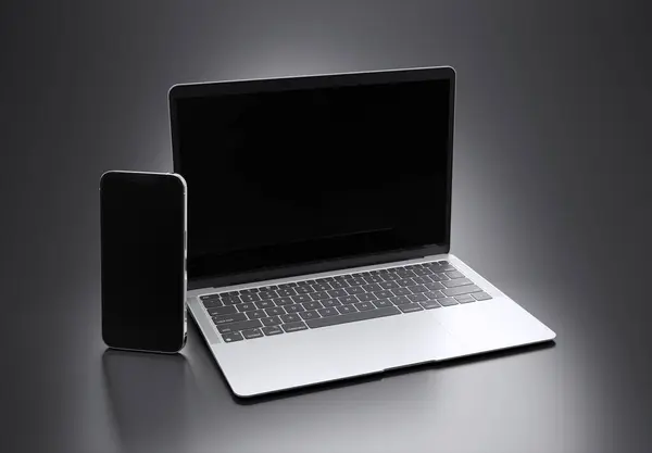 2023年3月15日 新发布Apple Macbook Air和Iphone Silver Color 侧视图 3D在灰色背景下渲染笔记本电脑屏幕模型 免版税图库照片