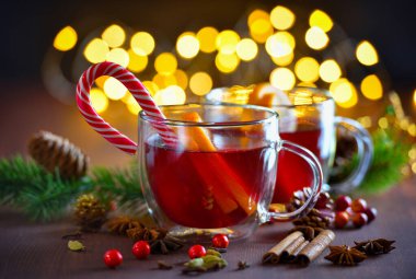 İki bardak yılbaşı şarabı ya da baharatlı ve portakal dilimli gluhwein şenlik ışıklarının arka planında. Geleneksel sıcak içecek Noel zamanı
