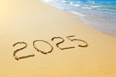 Yeni yıl 2025, kumda yazılı.