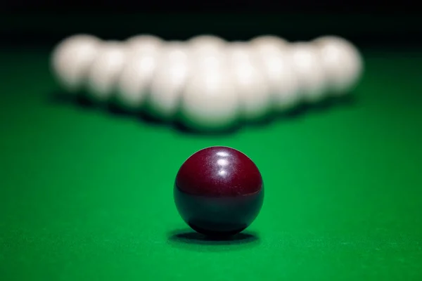 Red ball is displayed on the pool table against the background of other balls