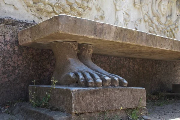 Nieborow 'da bir parkta oyulmuş taş ayakların üzerinde duran tarihi bir taş bank..