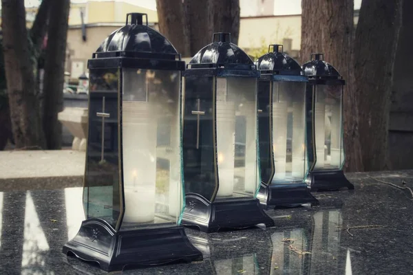 Parlak siyah bir mezar taşına dizilmiş dört mum..