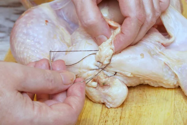 Doldurulmuş tavuğu dikiyorum. Pişirmeye hazırlanıyorum.