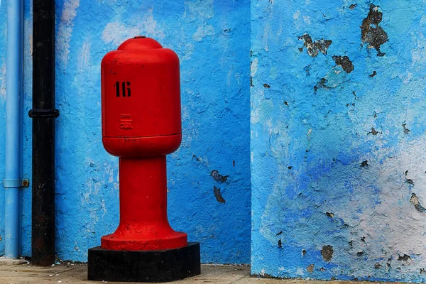 red hydrant by the blue wall