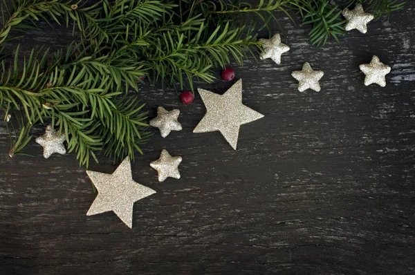 用冷杉和闪亮的星星装饰在木制背景上的圣诞装饰品 案文的篇幅 — 图库照片#