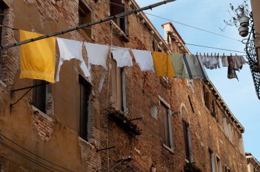 Venedik 'te bir caddede çamaşır ipinde çamaşır kurutma. Tuğladan evleri olan eski cadde