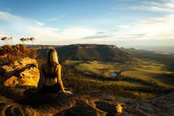 Mujer Sentada Alto Acantilado Montaña Mira Hacia Valle Iluminado Por — Foto de Stock