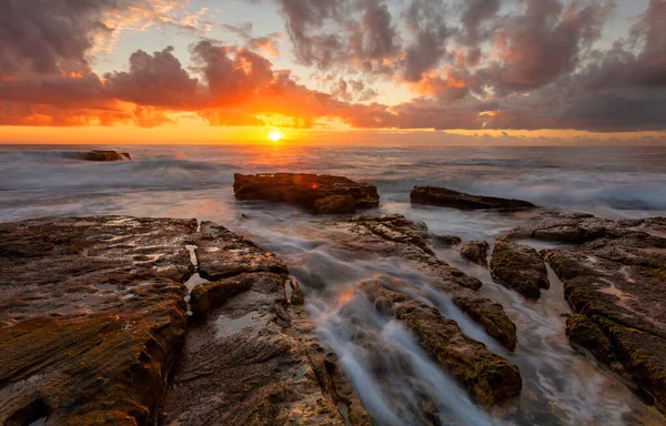 Tangerine Sonnenaufgang Über Dem Ozean Mit Schönen Kaskaden Und Gezeitenstrom lizenzfreie Stockfotos