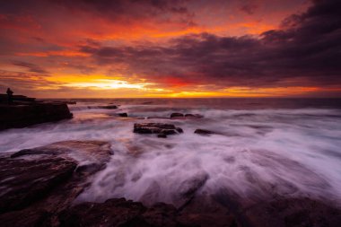 Vivid sky sunrise over the rocky coast of Sydney Australia clipart