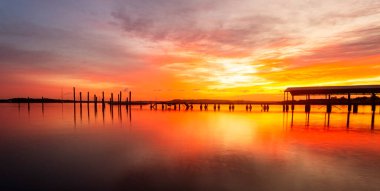 Uzun iskeleli iskele, kırsal yaşlı sütunlar, kızıl gündoğumu gökyüzü