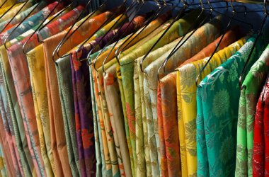  View of Indian woman traditional dress sarees in display, on hangers in a shop                                           