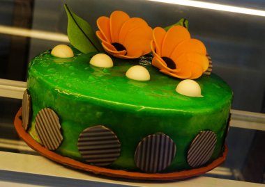  Close-up view of decorated cake in refrigerated display unit of a bakery shop                                