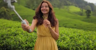 Vlogger gezgini kadın, Sri Lanka 'daki ünlü doğa manzaralı çay çiftliklerine seyahat izni uygulaması ile cep telefonu kamerasından video kaydediyormuş. Gen Z yetenek mutlu kız etkileyicisi video yapıyor