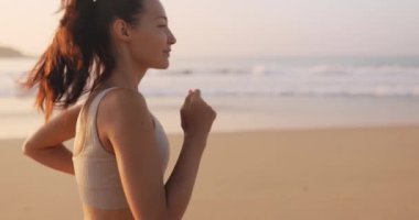 Koşan kadın. Sahilde spor yaparken koşan bir bayan koşucu. Açık havada çok güzel bir fitness modeli. c