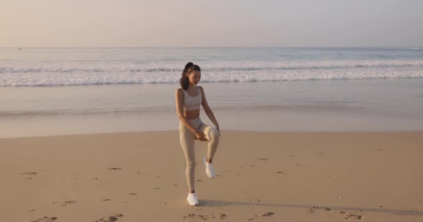 Красивая Спортивная Юная Спортсменка Тренировочной Одежде Растягивает Ноги Тело Пляже — стоковое видео