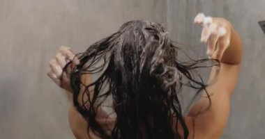 Duş alırken saçlarını şampuanla yıkayan çıplak bir kadın. Yüksek kalite 4k görüntü