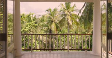 Yağmur ormanlarına ve palmiye ağaçlarına bakan bir villa balkonundan güzel bir manzaranın yavaş çekim görüntüleri.
