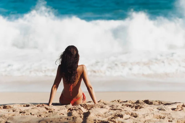 比基尼海滩的女人坐在沙滩上的海边 黑发白人女孩模特儿看着海浪的后视镜 浪漫的热带度假的概念 — 图库照片