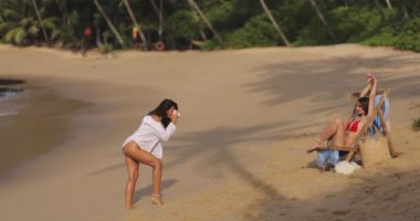 Kız arkadaş fotoğrafçısından seksi bikinili kadın modelinin plaj fotoğrafı. Tropik bir plajda bikiniyle poz veren muhteşem genç bir kadın romantik fotoşopu için mükemmel bir poz veriyor..