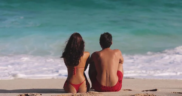 砂浜で海に座っている間 男と女が話している ブルネットの白人女性と男が波を見て カメラに背を向けて座っている ロマン主義の概念 — ストック写真