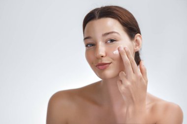 Cilt beyazlatma ya da solaryum bronzlaştırma konsepti. Kozmetik krem süren Asyalı güzellik kadını. Koyu tenle açık tenin karşılaştırıldığında. Yüksek kaliteli fotoğraf.