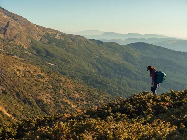 Stock image Descent of hiker tourist woman with backpack during mountain trekking from the top.