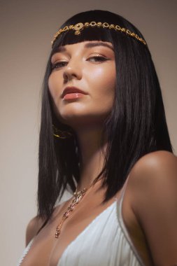 Queen Cleopatra stüdyo güzellik portresi. Mükemmel makyajlı, düzgün saç kesimi peruklu, şık altın takılar takan genç bir moda kadını. Güzellik için yüksek kaliteli kavramsal fotoğraf