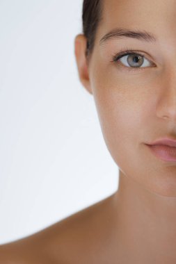 Cilt bakımının ve kozmetik konseptinin kaliteli fotoğrafı. Güzel yüzlü bir kadın sağlıklı yüz portresine dokunuyor. Doğal makyajlı güzel mutlu Asyalı kız modeli parlayan hidratlı derinin tadını çıkarıyor.