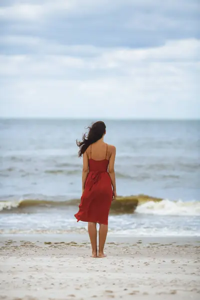 Удумлива Пляжна Жінка Червоній Сукні Стоїть Холодну Вітряну Погоду Хвилі — стокове фото