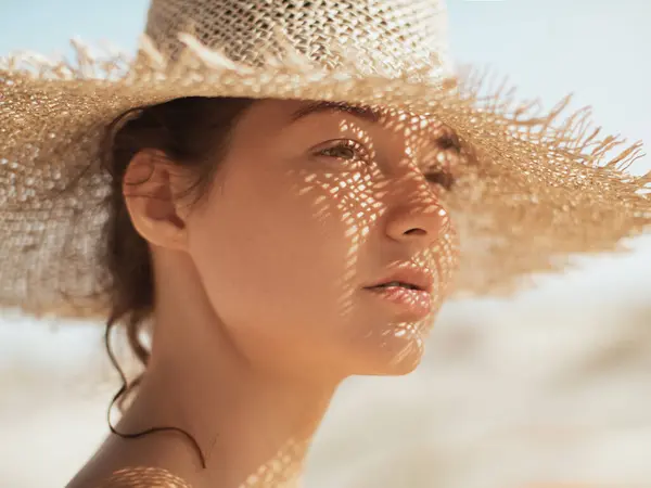 度假期间的海滩太阳帽女 女孩头戴草帽的特写镜头 一边欣赏阳光一边看 图库图片