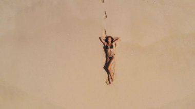 Hava aracı beyaz kum palmiyeleri, temiz su ve siyah bikinili bir kadın modelle güzel bir tropikal plaja sahiptir. Fotokopi alanı olan seyahat ve tatil mekanı konsept görüntüler