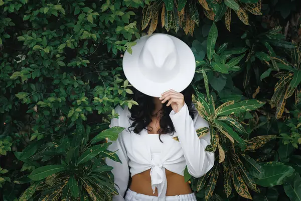 エキゾチックな植物の間でジャングルに立っている美しい日焼けしたファッショナブルな少女の夏のファッションの服 高品質の広告写真 ストックフォト