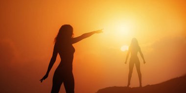 İki güçlü kadının siluetleri, canlı bir günbatımına karşı çift pozlama görüntüsüyle, gücü, birliği ve kadın haklarını temsil ediyor. İlham verici, motive edici ve...