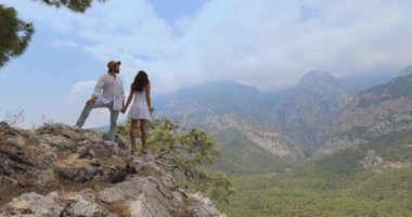 Türkiye 'nin Antalya kentinde manzaralı bir dağ manzarasında el ele tutuşan bir çiftin yüksek kaliteli görüntüleri. Seyahat blogları, romantik kaçamaklar ve macera temalı içerik için mükemmel..